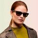 Женщина в классических черных очках Ray-Ban Wayfarer, подчеркивающих универсальность унисекс-дизайна и винтажный шик